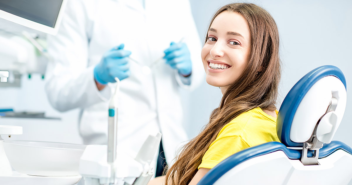 woman in a dentist chair, smiling