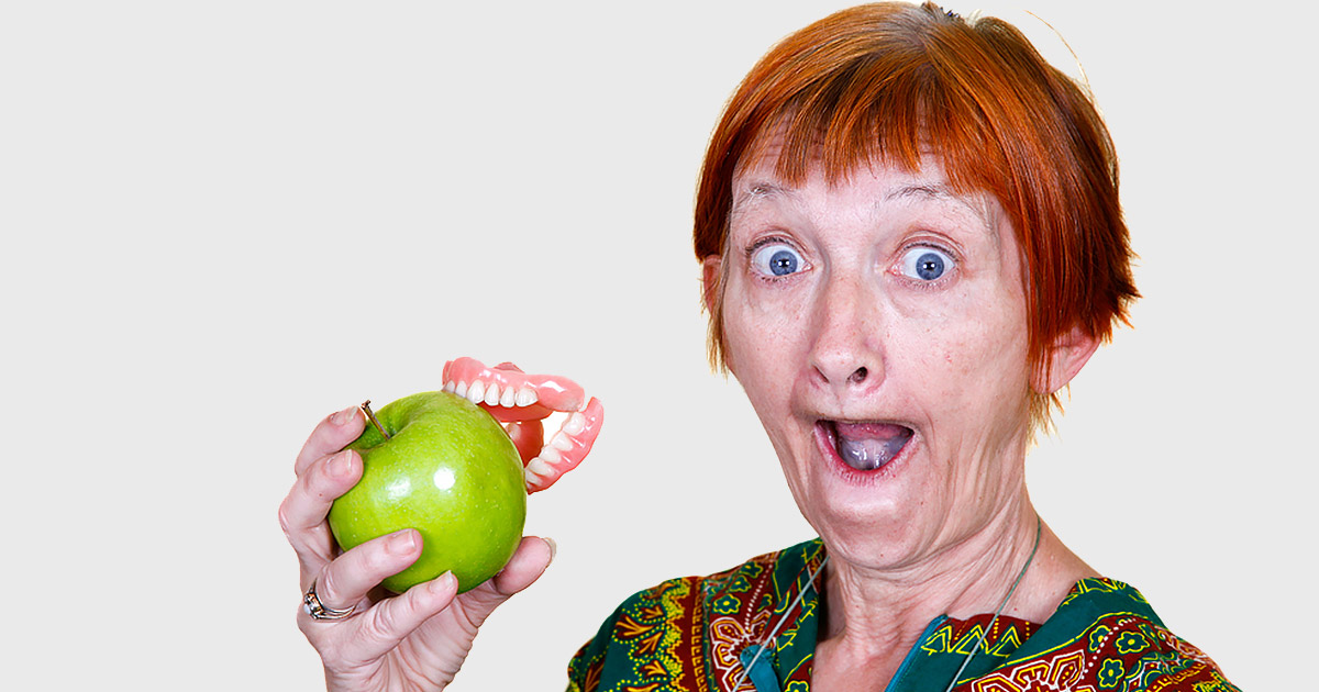 woman eating an apple and her dentures came out