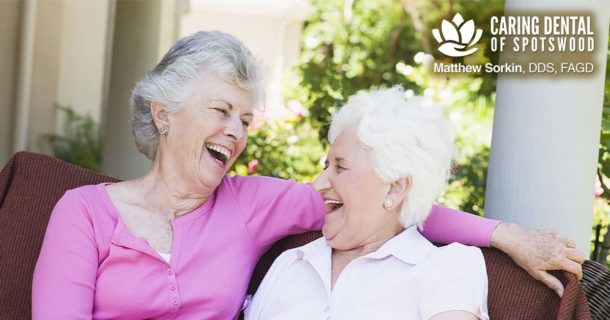 two, older women siting together smiling and laughing